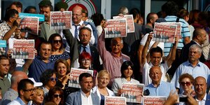 Menschen halten die Zeitung Cumhuriyet in die Luft