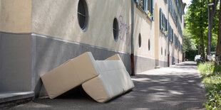 Ein altes Sofa liegt auf einem Bürgersteig in Freiburg.