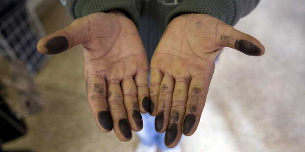 Ein Flüchtling zeigt seine Hände, nachdem er seine Fingerabdrücke für das Asylverfahren abgeben musste.