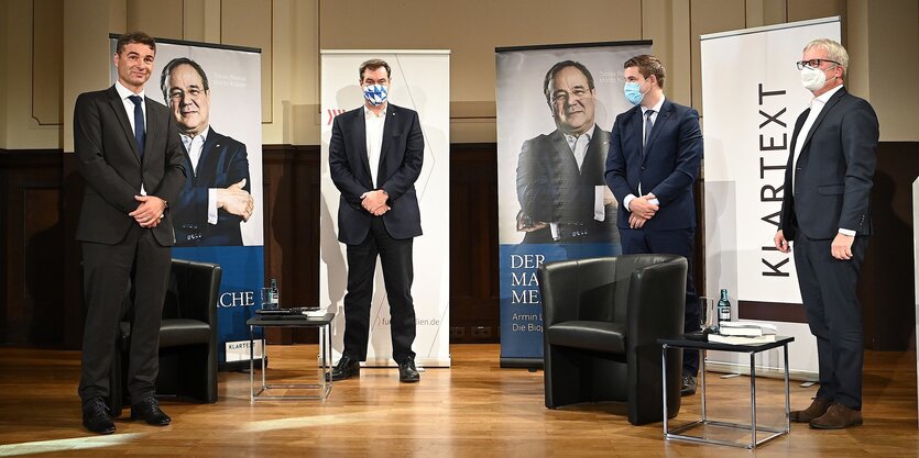 Männer im Anzug auf einem Podium