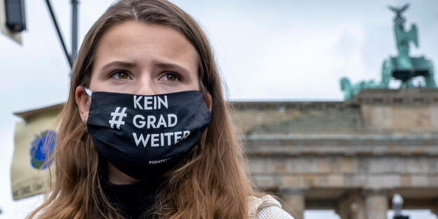 Klimaaktivistin Luisa Neubauer trägt eine Coronaschutzmaske mit dem Slogan Kein Grad weiter