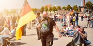 Gegen Corona-Maßnahmen Demonstrierender hält Deutschland-Flagge hoch