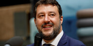 Matteo Salvini lächelt und hält sich ein Mikrofon vor den Mund.