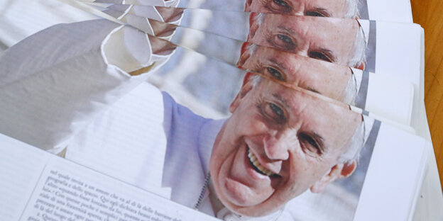 Mehrere Zeitungsausgaben. Die Titelseite zeigt den Papst