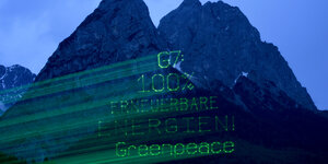 Laserschriftzug von Greenpeace an einem Berg