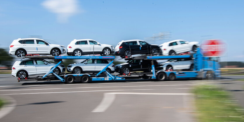 Ein Autotransporter mit Neuwagen von Volkswagen fährt über eine Landstraße