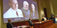 homas Perlmann (r), Sekretär der Nobelversammlung, gibt die Nobelpreisträger 2020 in Medizin während einer Pressekonferenz im Karolinska-Institut bekannt.Sie sind auf einer Leinwand mit Foto zu sehen.