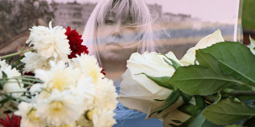 Das Portrait der Frau auf einer Fotografie und Blumen