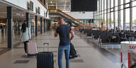 Passagiere mit Koffern im Flughafen Schönefeld