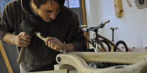 Ein Mann arbeitet in einer Werkstatt mit Holz