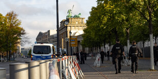 Polizisten stellen in der Nähe des Brandenburger Tors Absperrgitter auf