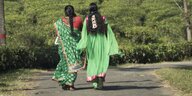 Zwei Frauen, vermutlich Mutter und Tochter, gehen in bunten Gewändern spazieren