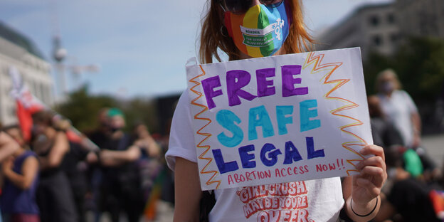 Eine Demonstrantin hält ein Schild mit der Aufschrift: Free, safe, legal, Abortion Access Now !!