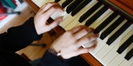 Zwei Hände spielen Klavier