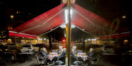 Eine abendliche Szene in einer Kneipe in Wilmerdorf: Alkohol trinken in geselliger Runde und draußen