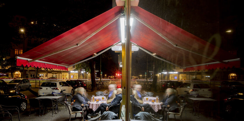 Eine abendliche Szene in einer Kneipe in Wilmerdorf: Alkohol trinken in geselliger Runde und draußen