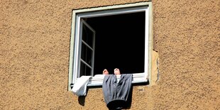 Füße und Hose zum Lüften am offenen Fenster