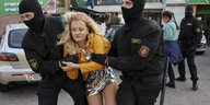 Anastasia Kasanowitsch wird von zwei maskierten Polizisten abgeführt