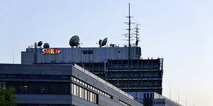 Das Gebäude des SWR von aussen mit einem leuchtenden Logo SWR