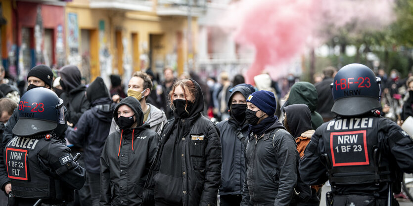 Polizisten führen eine Bewohnerin des Hauses ab