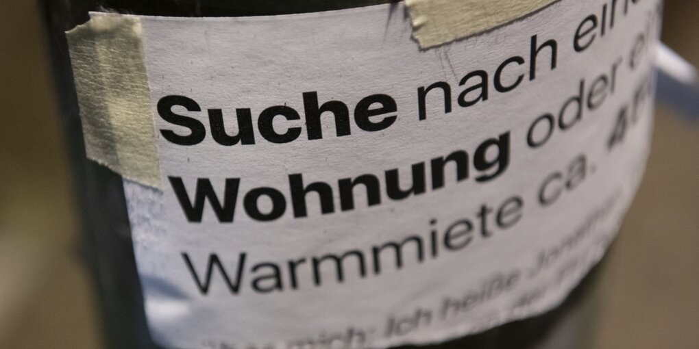 Ein Zettel auf dem steht: "Suche nach einer Wohnung"