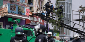 Polizist führt eine Bewohnerin der Liebig 34 über eine Leiter aus dem Haus