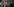 Latex-Schneiderin Pulkkinen sitzt auf dem Tresen ihres Ladens. Sie trägt selbst ein Latex-Outfit, im Hintergrund sind ihre ausgefallenen Kleidungsstücke zu sehen.