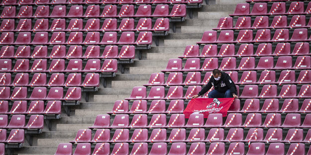 Ein einzelner Fan des 1. FC Köln auf einer leeren Tribüne im Stadion