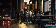 Junge Menschen drängen sich nachts vor einer Bar in Berlin. Sie halten keinen Corona-Abstand