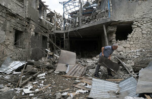 Ein Mann räumt Trümmer auf im Hof eines Hauses, das während eines Granatenbeschusses der aserbaidschanischen Artillerie zerstört wurde.