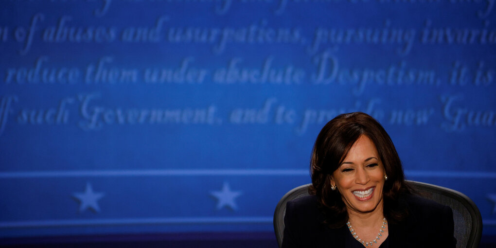 Eine Frau vor einem blauen Hintergrund. Es ist die Politikerin Kamala Harris