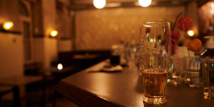 Halbvolles Bierglas in einer Kneipe