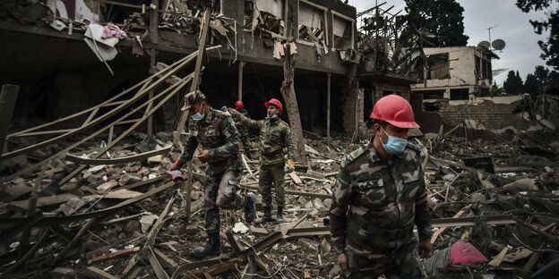 Soldaten laufen in den Trümmern eines Hauses herum