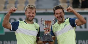 Kevin Krawietz und Andreas Mies aus Deutschland feiern mit der Trophäe den Finalsieg.