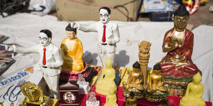 Figuren von Buddha und Mann im Anzug