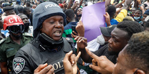 Polizist diskutiert mit erregten Demonstranten