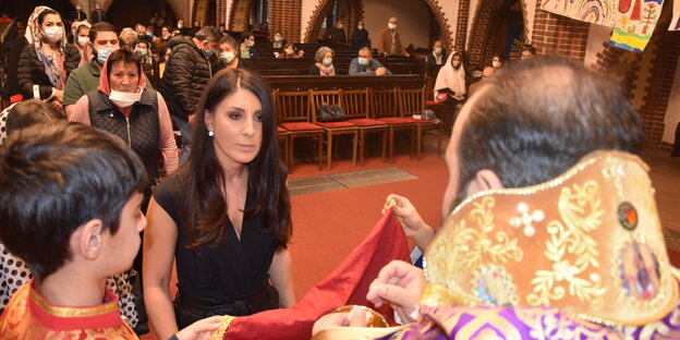 Menschen stehen in einer Schlange vor dem Altar fürs Abendmahl an: Am Gottesdienst der armenischen Gemeinde nehmen mehr Menschen teil als sonst