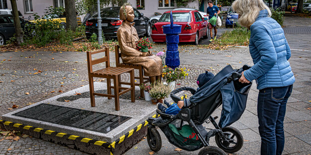 Bronzestatue einer jungen Frau die auf einem Stuhl sitzt