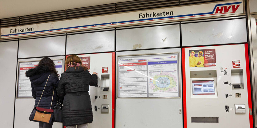 Zwei Frauen stehen mit dem Gesicht zu einem Fahrkartenautomat des HVV