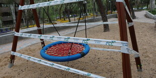 Eine Schaukel auf einem Spielplatz in Madrid ist mit einem Plastikband abgesperrt