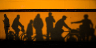 Schatten von Menschen an einer Hauswand