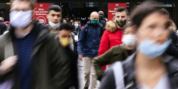 Menschen mit Masken auf der Straße.