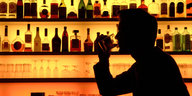Ein Mann sitzt an einer Bar und trinkt