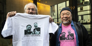 John Shipton und Ai Weiei mit T-Shirts, auf denen die Freilassung von Julian Assange gefordert wird.