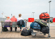 ine dreiköpfige Familie wartet mit ihrem Gepäck am Fährhafen von Harlesiel auf die Abfahrt der Wangerooge-Fähre