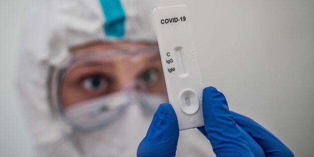 Ein Mitglied des medizinischen Personals prüft einen Schnelltest zum COVID-19-Antikörper-Nachweis