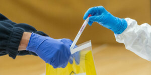 Ein Coronatest wird in eine Labortüte gepackt.