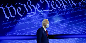 Joe Biden mit Maske vor einer blauen Wand