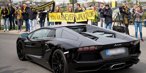 Ein schwarzer Lamborghini vor jubelnden Dortmunder Fans