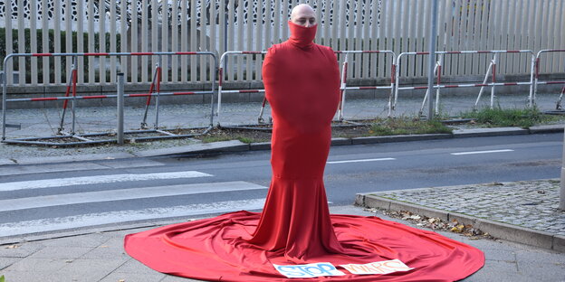Mann in rotem Gewand, das wie ein Hochzeitskleid aussieht